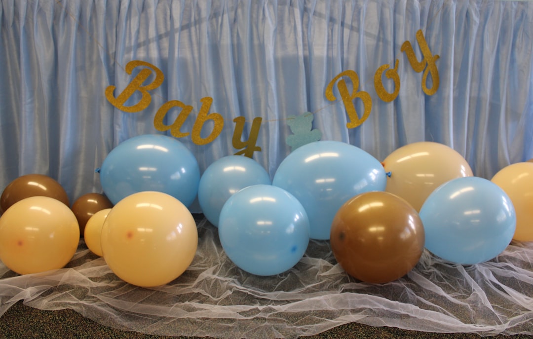 A beautifully arranged baby shower table with pastel decorations, balloons, and floral centerpieces.