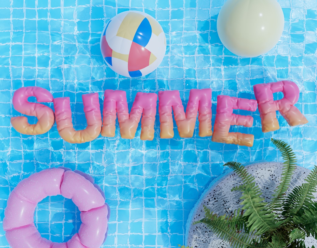 Colorful pool party decorations and supplies arranged by a swimming pool