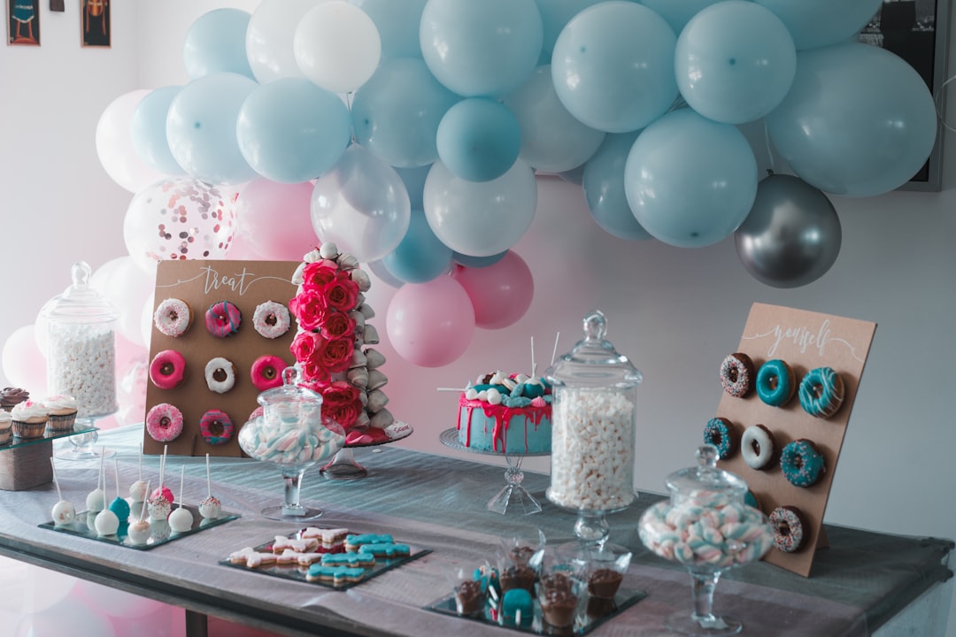 A beautifully decorated party table with simple yet elegant decorations, including balloons, flowers, and table settings.